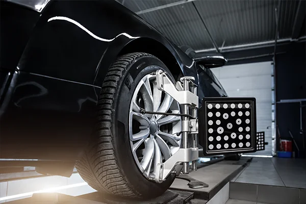 Black car sitting on alignment rack 