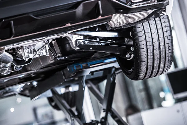Underside of vehicle on lift showing suspension components