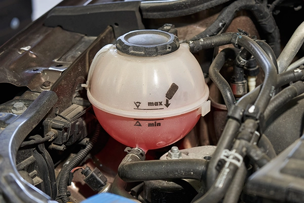 Red coolant in reservoir in-between maximum and minimum level