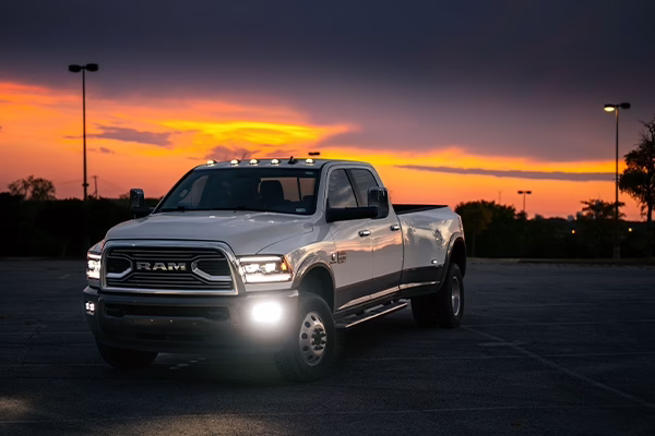 White RAM Cummins diesel pickup parked in front of sunset