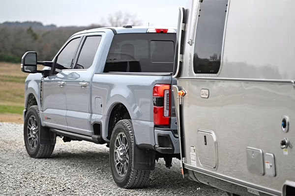 Grey Ford Powerstroke diesel truck pulling silver trailer